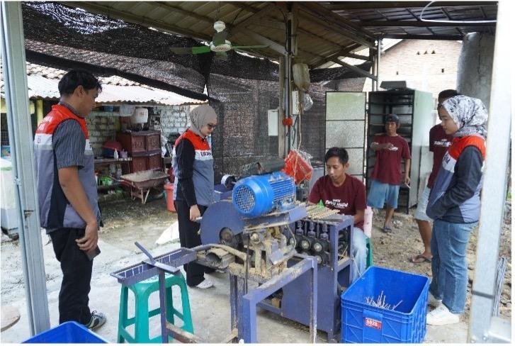 A group of people working on a machine AI-generated content may be incorrect.